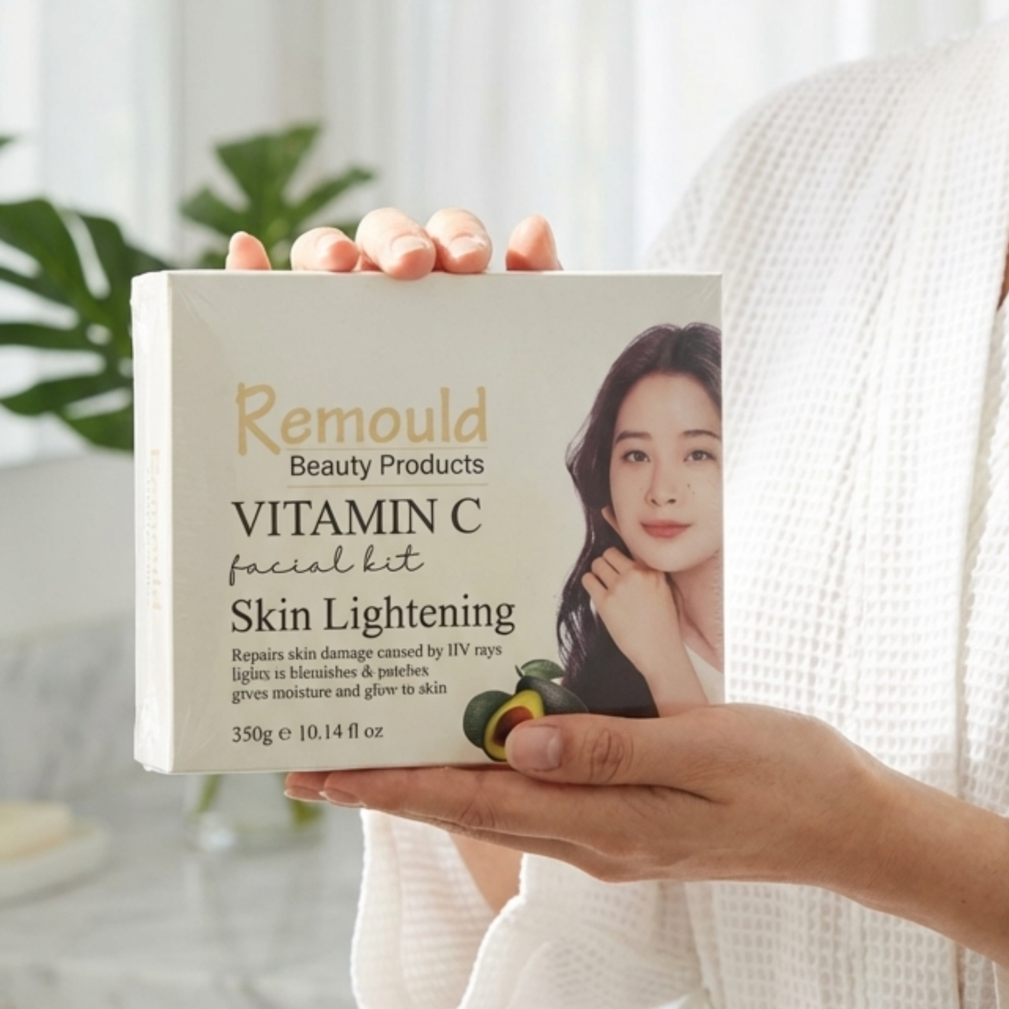 Woman holding Remould Vitamin C Facial Kit box showing skin lightening treatment with avocado ingredients and 350g size in bright natural setting
